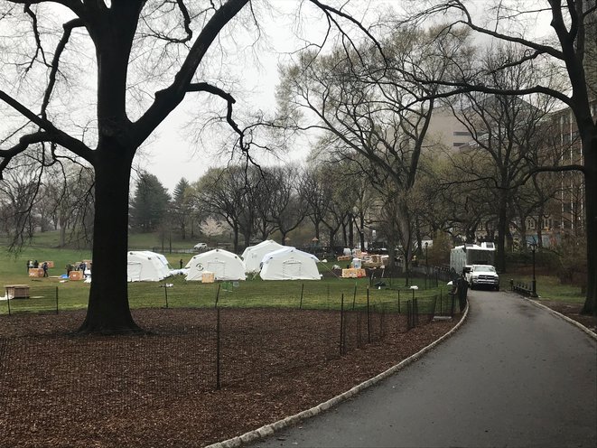 Workers assemble emergency field hospital tents in Central Park during the coronavirus pandemic.