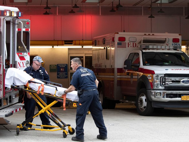 Paramedics place an empty collapsible wheeled stretcher into an ambulance after delivering a patient into the emergency room at NewYork-Presbyterian Lower Manhattan Hospital, in New York.
