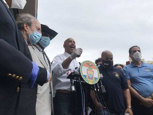 Bronx Borough President Ruben Diaz Jr. behind a podium, stands with elected officials condemning looting and vandalism during last night's protests.