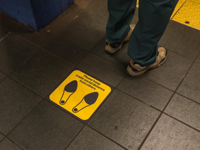 A social distance marker on the subway platform