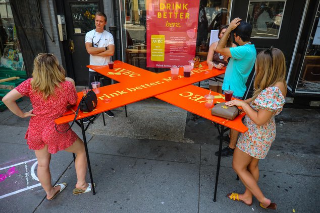 A table shaped like an 6 to keep people standing 6 feet apart on a sidewalk
