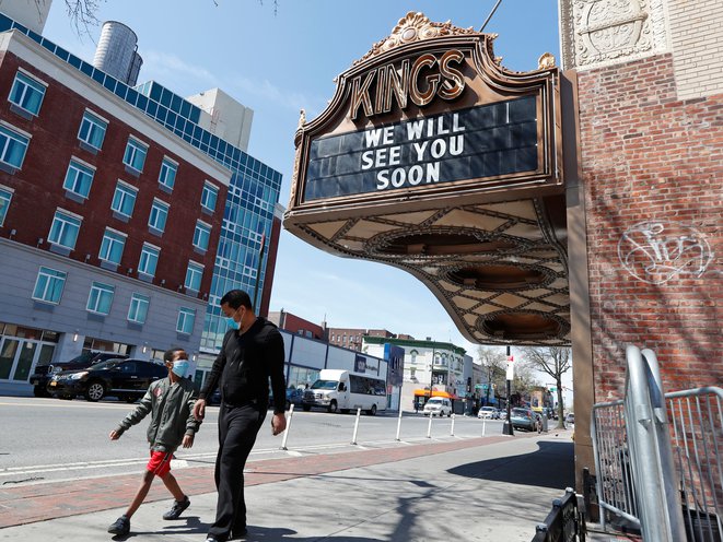 A man and a youngster the required wearing face coverings walk along Brooklyn's Flatbush Avenue April 14th, 2020. KATHY WILLENS/AP/SHUTTERSTOCK