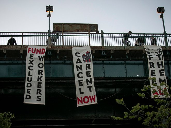 People unfold banners from a subway platform in Queens May 21st, 2020.