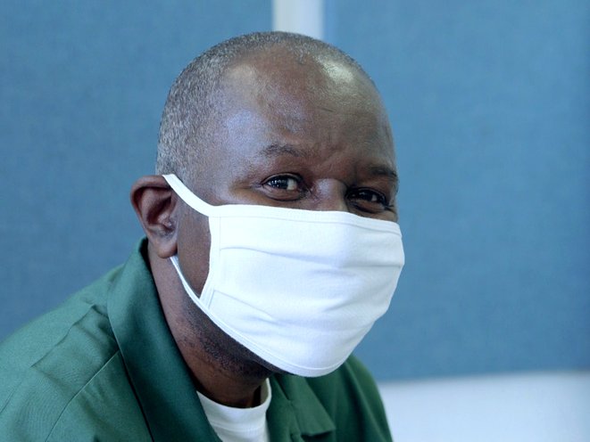 A picture of prisoner Yohannes Johnson, 64, wearing a white mask.