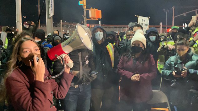 Representative Alexandria Ocasio-Cortez wears a mask as she speaks into a megaphone at a strike outside the Hunts Point Produce Market on January 17th.