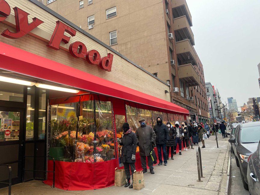 New Yorkers wait in line at a key food supermarket as many residents rushed to get groceries before the snowstorm.