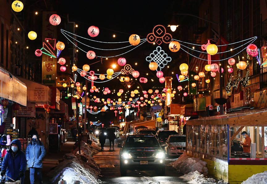 A night shot of illuminated lanterns strung across the street