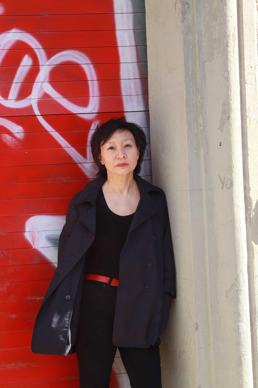 Cathy Park Hong stands in front of a door
