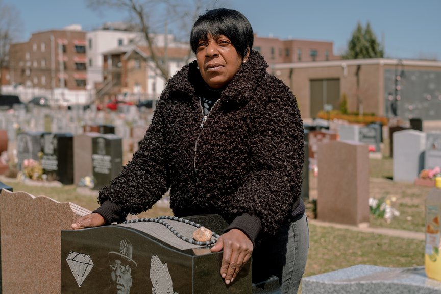 Roberto Grant's mother Crecita Williams stands by his tombstone.