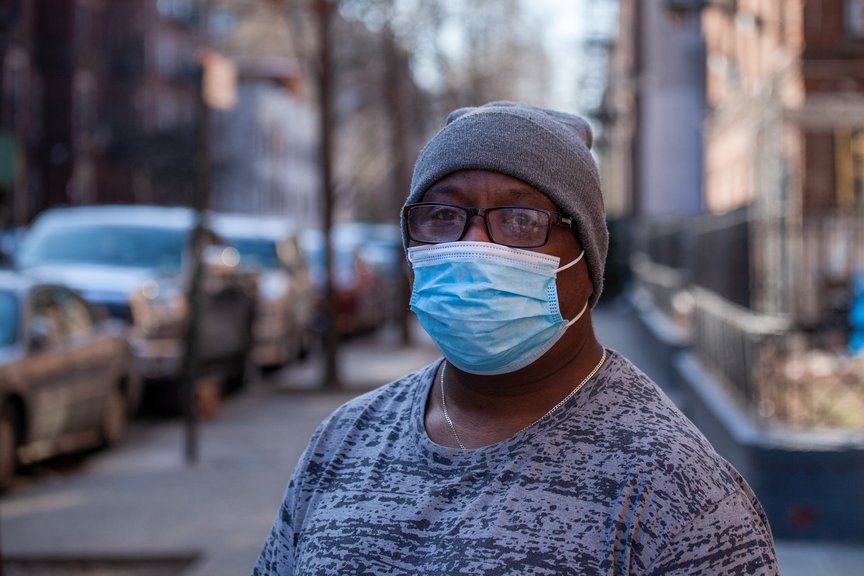 A photo of Arthur Ceasar, wearing a blue surgical mask over his face.