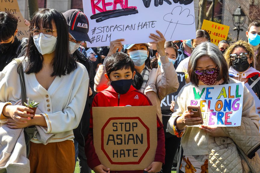Protesters hold signs decrying hate crimes at the Stop Asian Hate rally in Columbus Park, Manhattan, March 21, 2021