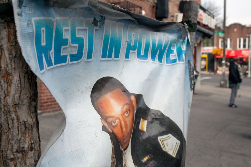 A poster that says "Rest in Power" with a photo of Vassell