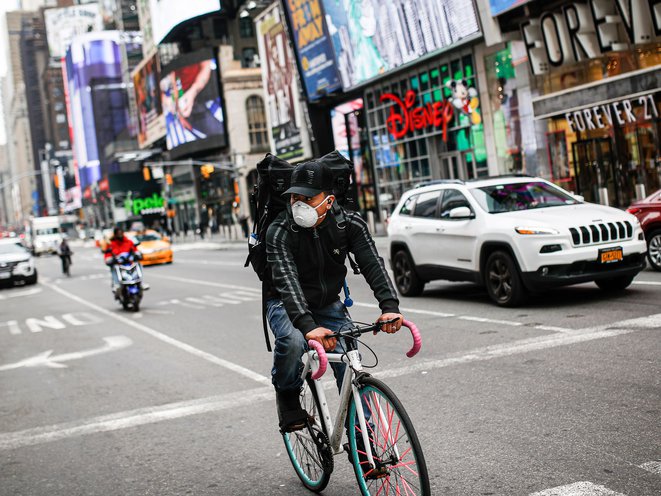 A delivery cyclist rides their bike through Times Square during the height of the pandemic in March of 2020.