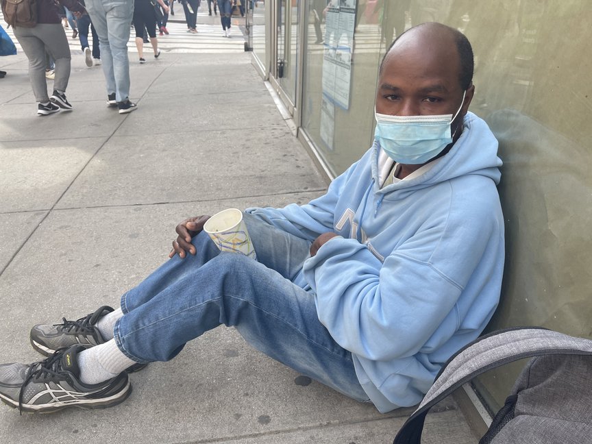 Henry Hamilton sitting on a sidewalk in Midtown.