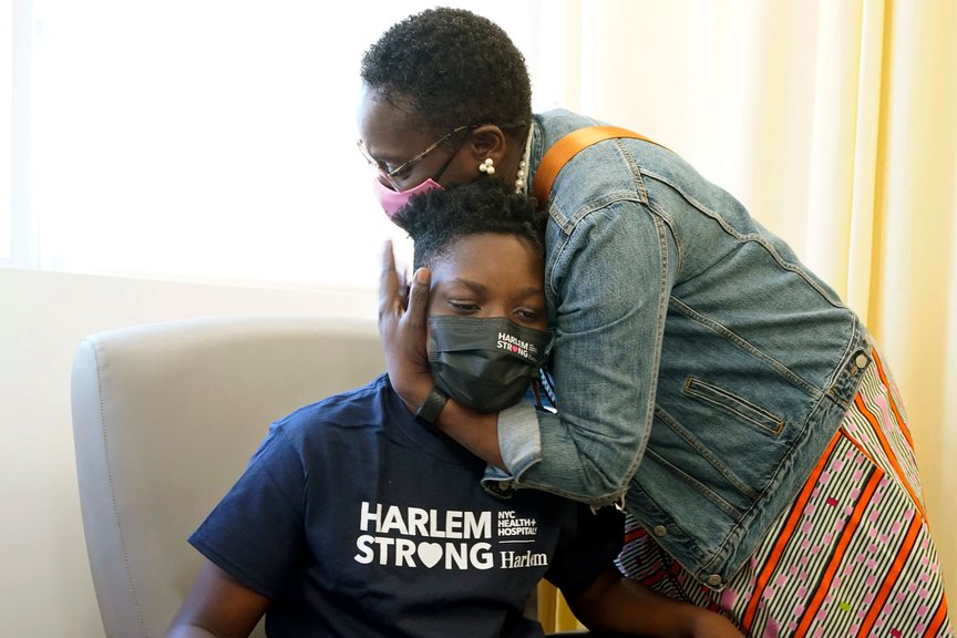 Julian Boyce, 14, gets a hug from his mother, Satrina Boyce, after he received his first Pfizer COVID-19 vaccination dose at NYC Health + Hospitals/Harlem, May 13th, 2021