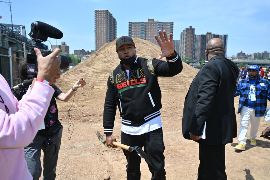 LL Cool J pumps a fist and holds a shovel in the other hand after the groundbreaking