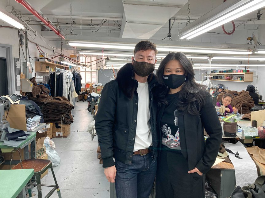 Arun Ochirvaani and Lisa Sun, both masked, pose for a photograph inside the factory