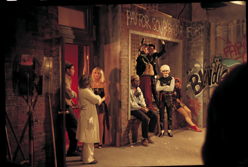 A photo of Debbie Harry, Jean-Michel Basquiat, and Fab 5 Freddy with others on the set for the music video of "Rapture"