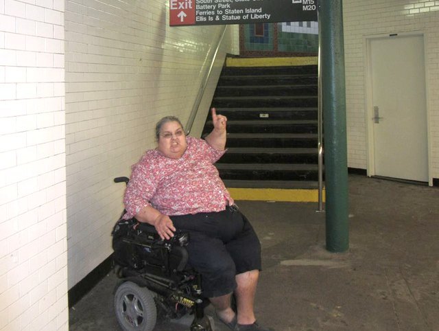 Edith Prentiss in the wheelchair points to the stairs, which she cannot use