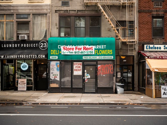 A bodega is closed, and there's a "for rent" sign on its gate