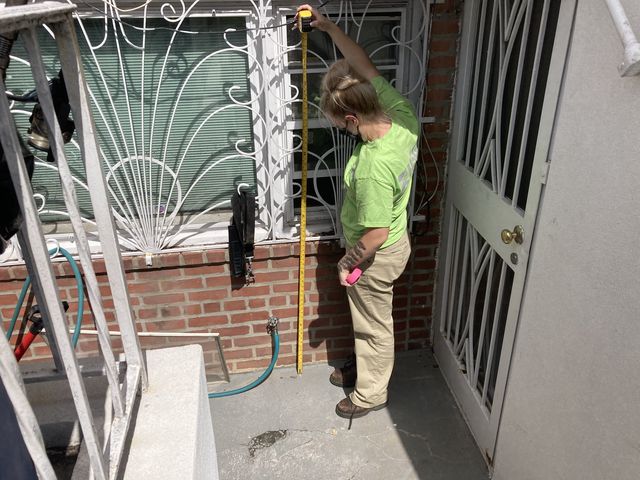 A USGS worker measures flood levels outside a home in Pomonok, Queens, after the remnants of Hurricane Ida struck New York City in September 2021.
