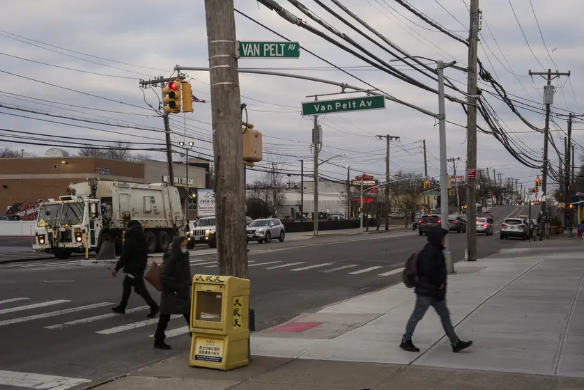 A crosswalk scene underneath two large street signs that both read "Van Pelt Av."