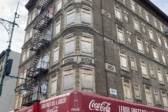 110 Lenox Ave. in Harlem has a closed retail space on the ground level, with boarded up apartment windows on the remaining five floors above.